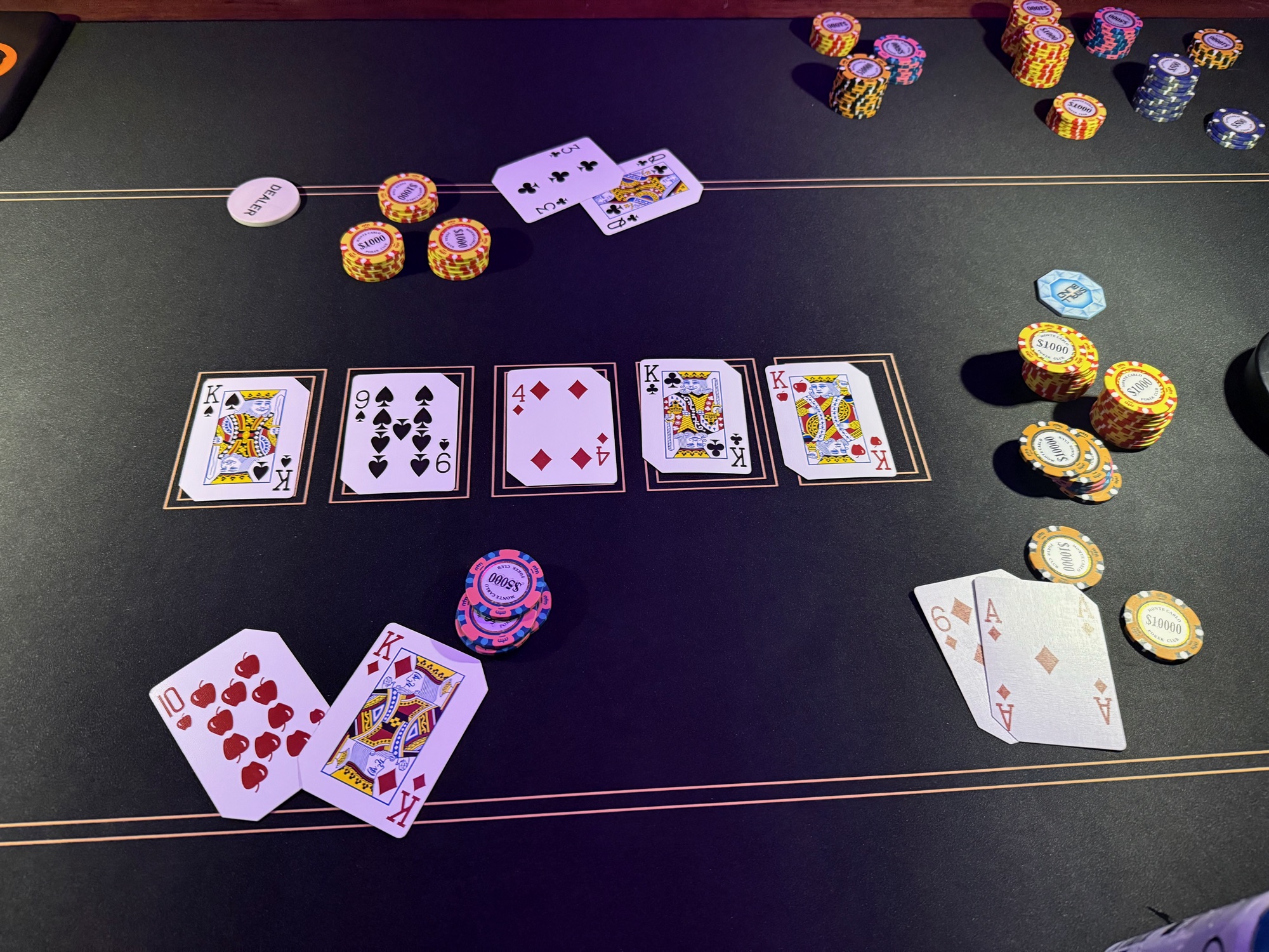 Chips, cards and a JPL dealer chip laid out on the felt mid-hand