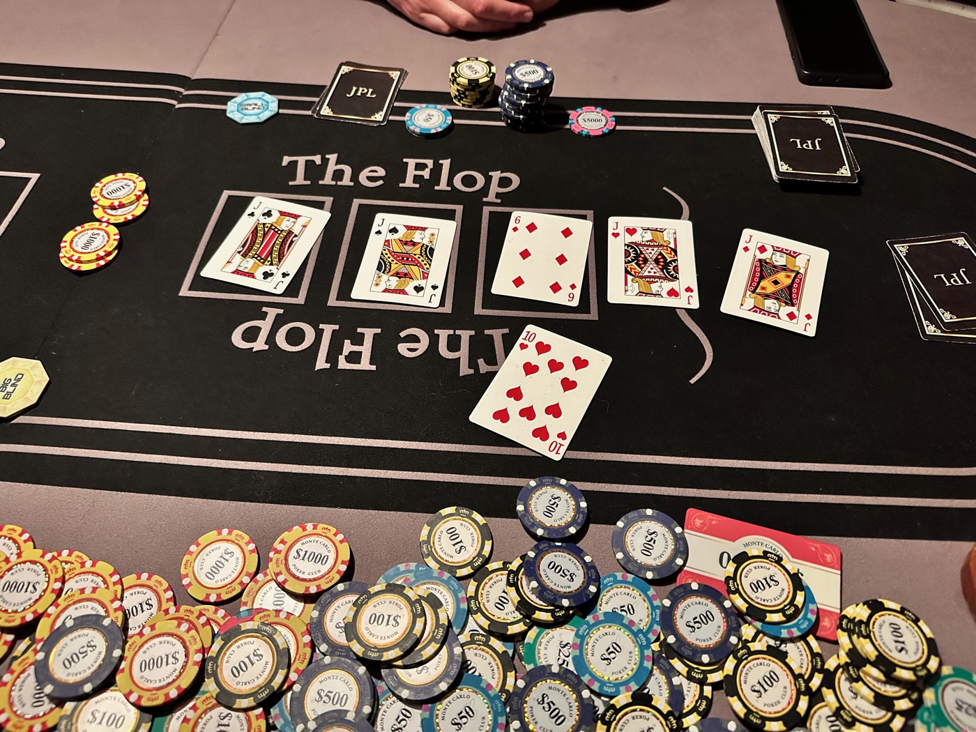 The flop laid out on the JPL branded felt, JPL playing cards beside it
