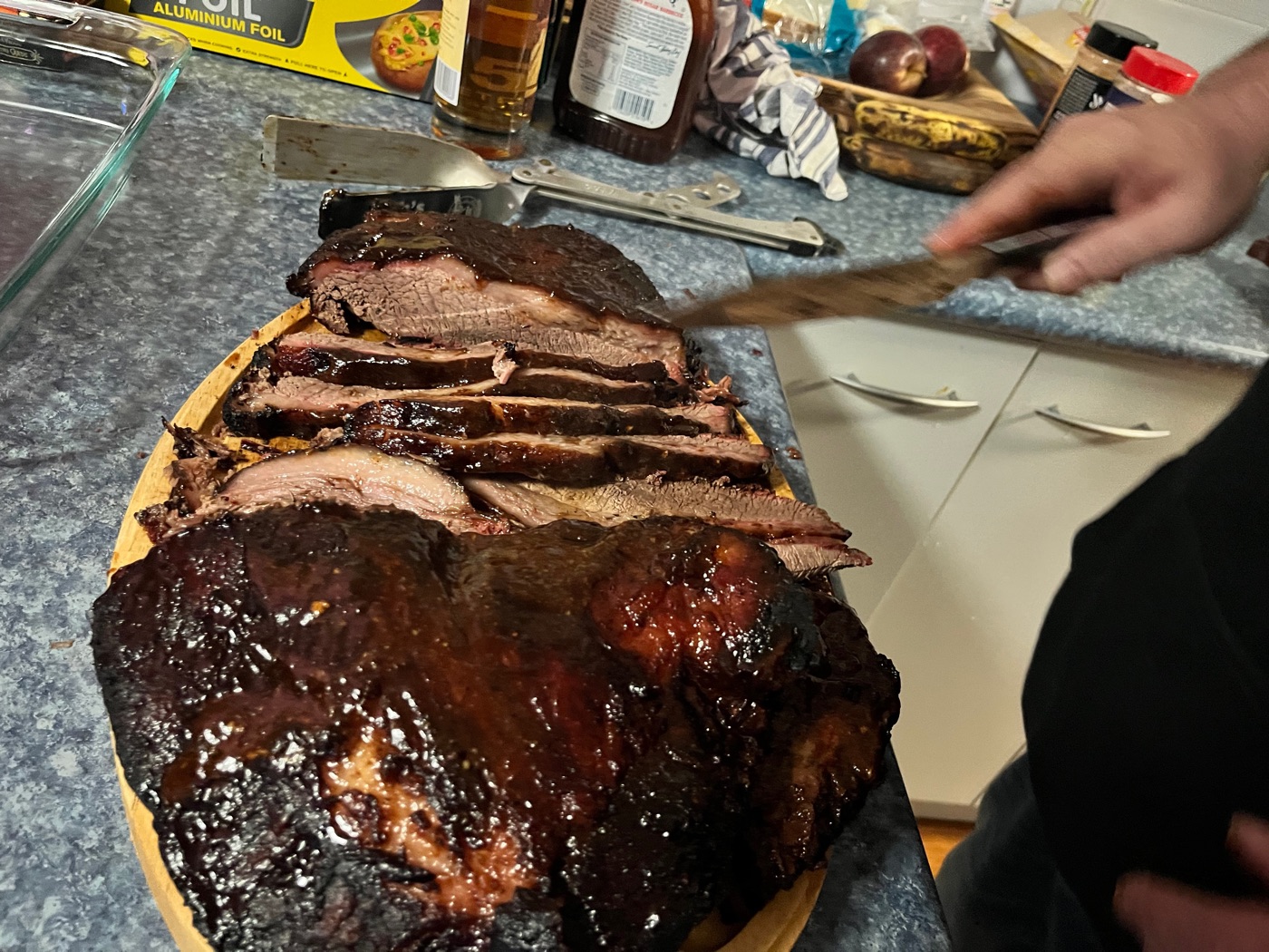 A finished brisket being sliced on the counter